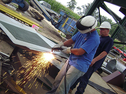 Man welding metal using welding rod